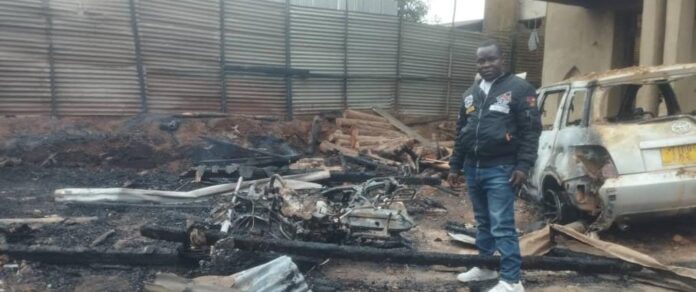 Débris calcinés d’une maison en planches et carcasse de véhicule après un incendie à Bwinongo, Butembo