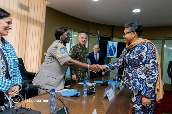 Salle de réunion officielle à Kinshasa avec table, documents et microphones, sans visage reconnaissable