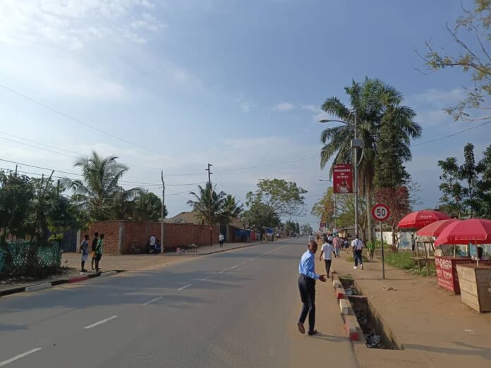 Avenue de Kindu peu fréquentée avec des taxis-motos et tricycles stationnés lors de la grève