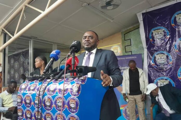 Salle de conférence à Kinshasa avec pupitre, micros et sièges vides à l'ouverture des Universités d'octobre