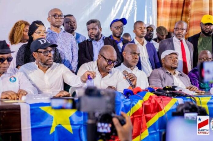 Micros et documents sur une table lors d’une déclaration de la Coalition Article 64