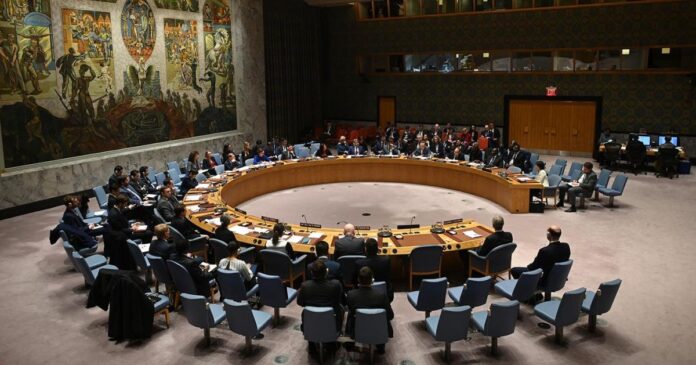 Salle du Conseil de sécurité de l’ONU avec tables incurvées, microphones et écran affichant une carte de la RDC