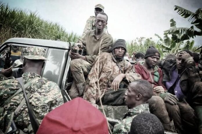 Position militaire de fortune dans une zone vallonnée du Nord-Kivu, avec sacs de sable et végétation dense