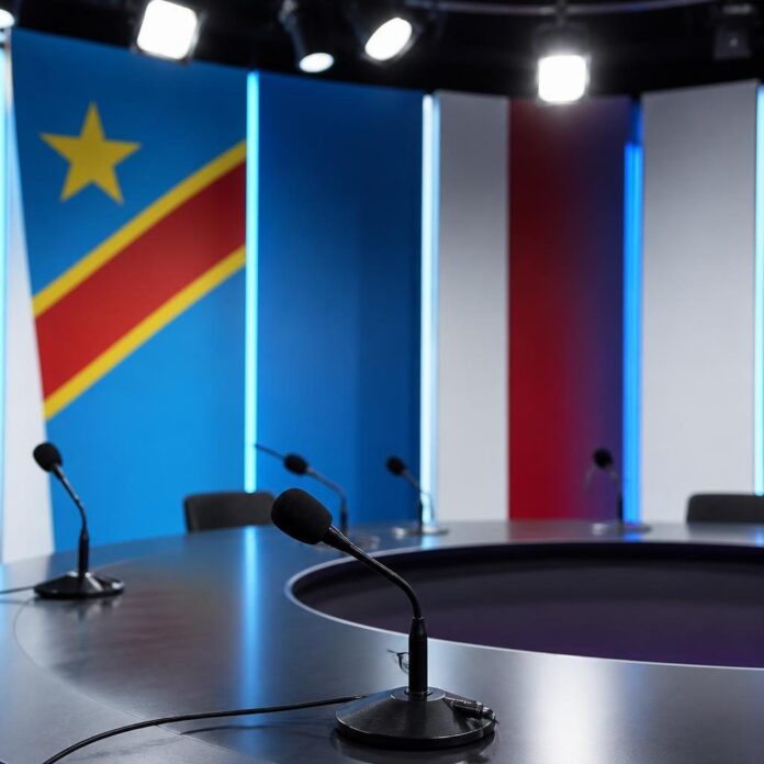 Studio de débat politique avec micros et sièges vides, ambiance RDC