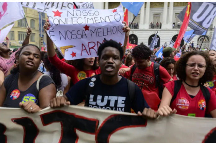 Foule de manifestants avec drapeaux et pancartes dans le centre-ville de Rio de Janeiro lors d'une marche contre Flavio Bolsonaro