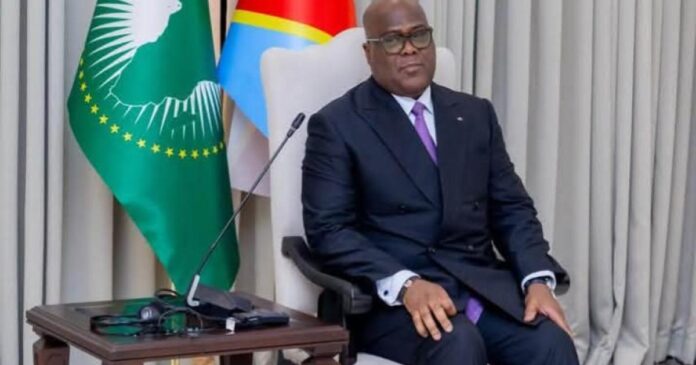 Micros de studio de radio posés sur une table devant un écran affichant une carte de l'est de la République démocratique du Congo