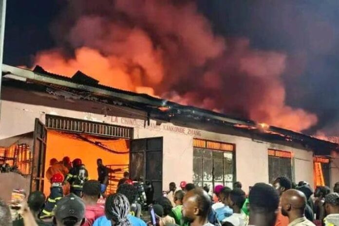 Secours et fumée près de magasins endommagés aux abords du marché central de Kinshasa