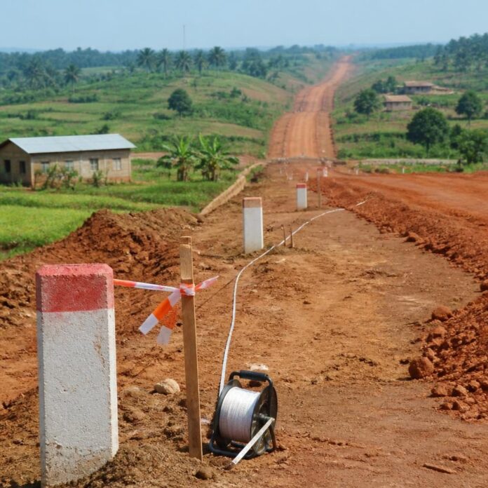 Des agents de recensement et des riverains le long de la route Kimpese-Kimbemba, avec des parcelles et des champs en arrière-plan